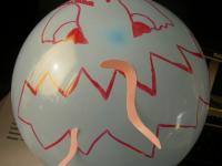 Doordat de ballon geladen is met statische elektriciteit, vliegen de snippertjes erop af. Het monster eet.